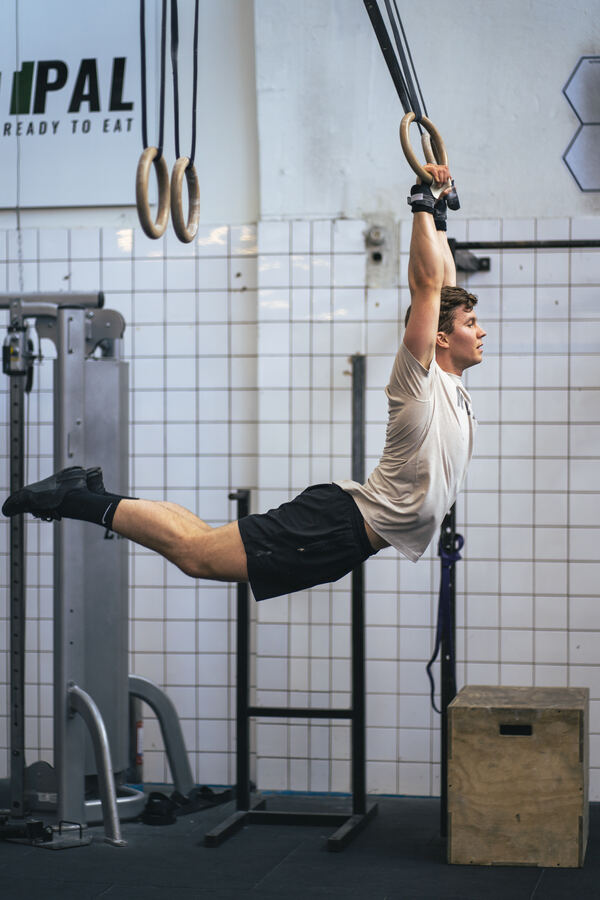 Fritz hanging from gymnastic rings in a horizontal hold