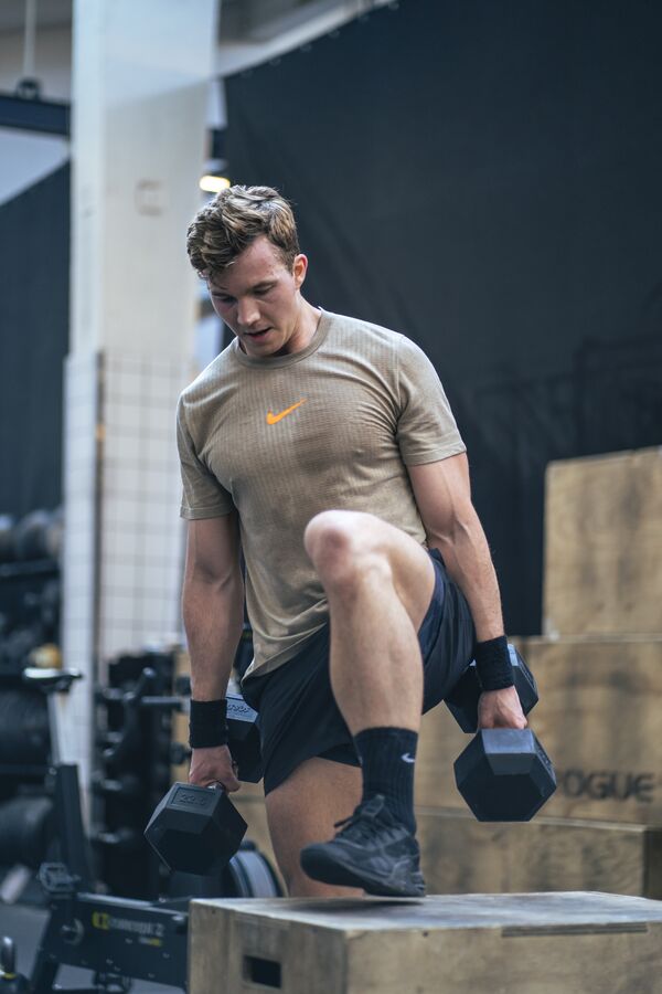 Fritz stepping up onto a box with dumbbells
